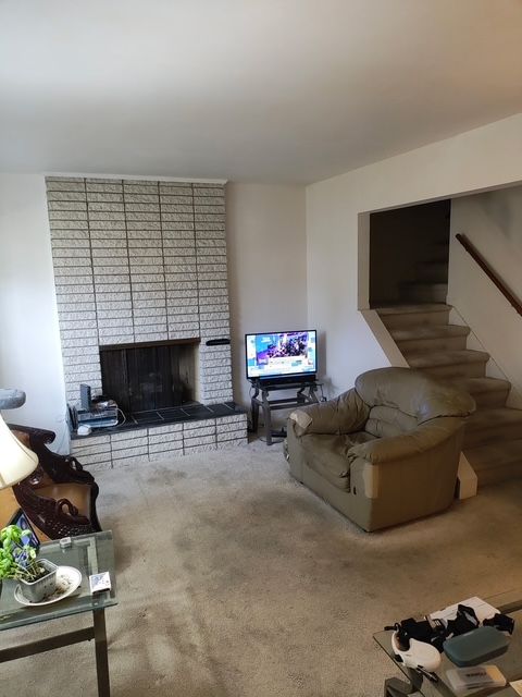 6689 Andersonville Rd Unit 29, Clarkston, MI 48346 - living room with carpet flooring, a fireplace, and stairway