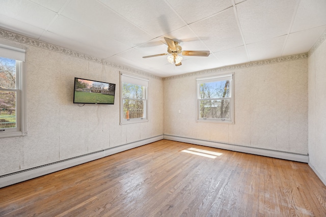 2050 Rowe Rd, Milford, MI 48380 - spare room with ceiling fan, wood finished floors, a baseboard heating unit, and a healthy amount of sunlight