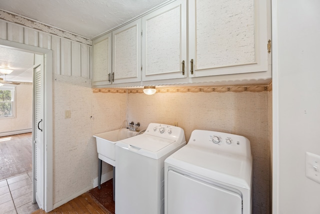 2050 Rowe Rd, Milford, MI 48380 - washroom featuring a baseboard heating unit, cabinet space, independent washer and dryer, and wood finished floors