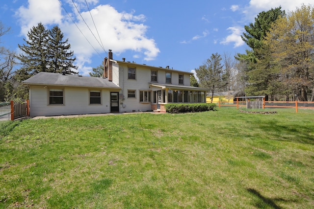 2050 Rowe Rd, Milford, MI 48380 - back of property featuring a sunroom, a chimney, a lawn, and a fenced backyard