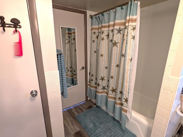 bathroom with wood finished floors and shower / bathtub combination with curtain