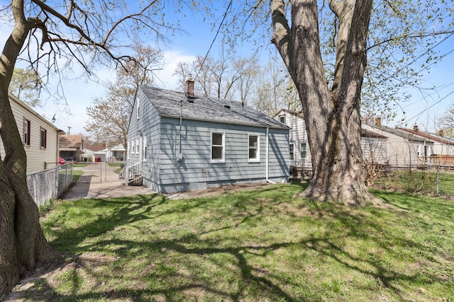 28320 Hillview St, Roseville, MI 48066 - back of house with a chimney, fence, a shingled roof, and a lawn