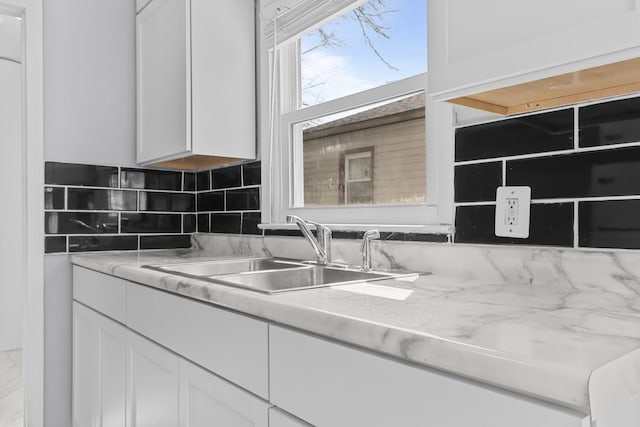 28320 Hillview St, Roseville, MI 48066 - details featuring light countertops, decorative backsplash, white cabinetry, and a sink