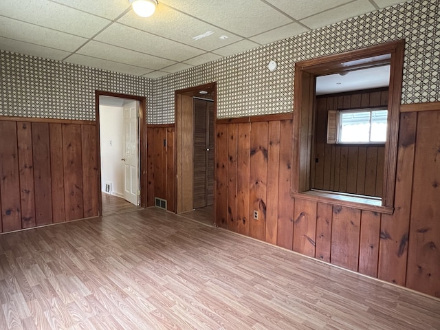 26741 Dartmouth St, Madison Heights, MI 48071 - unfurnished living room featuring wood finished floors, a wainscoted wall, a drop ceiling, wallpapered walls, and wooden walls