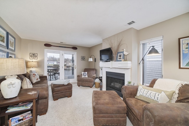 carpeted living room with visible vents and a fireplace