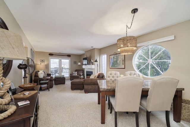 dining area with a chandelier, a fireplace, and carpet flooring