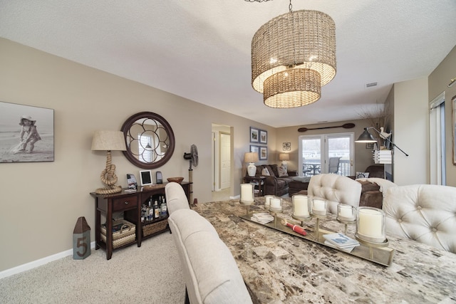 carpeted dining area featuring baseboards and a notable chandelier