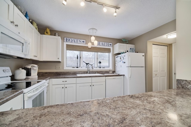 kitchen with white cabinets, a sink, a textured ceiling, dark stone counters, and white appliances