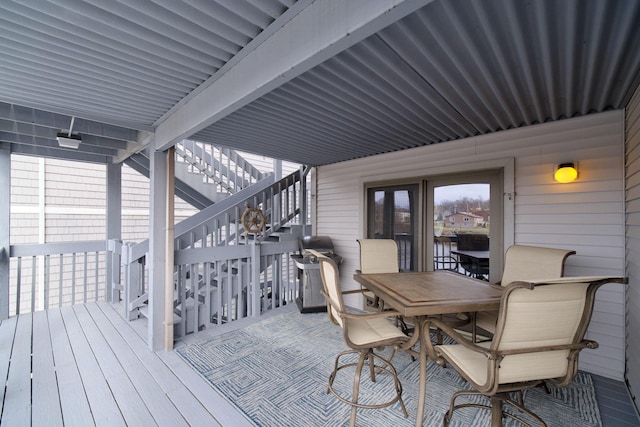 wooden deck featuring outdoor dining area and stairs