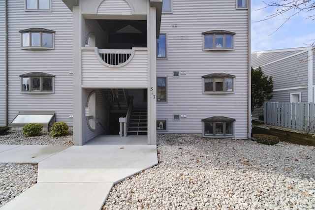 view of property featuring stairway and fence