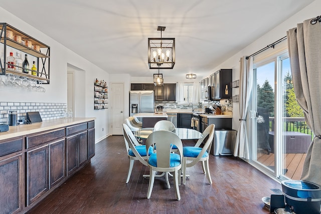 8079 Wildwood Ln, White Lake, MI 48386 - dining room featuring dark wood-style floors, plenty of natural light, a chandelier, and baseboards
