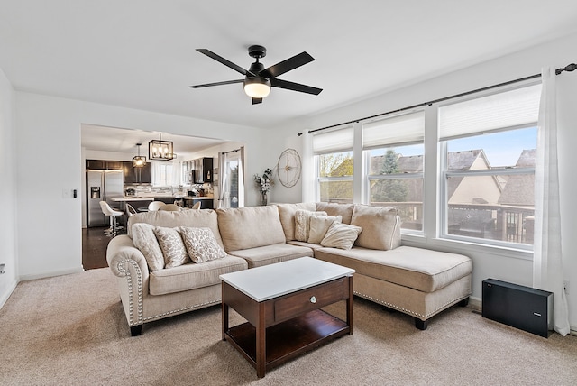 8079 Wildwood Ln, White Lake, MI 48386 - living room with carpet floors, a ceiling fan, baseboards, and a chandelier