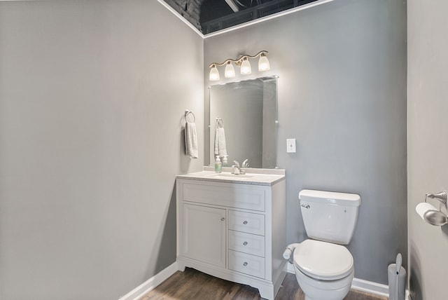 8079 Wildwood Ln, White Lake, MI 48386 - half bath featuring wood finished floors, baseboards, toilet, and vanity