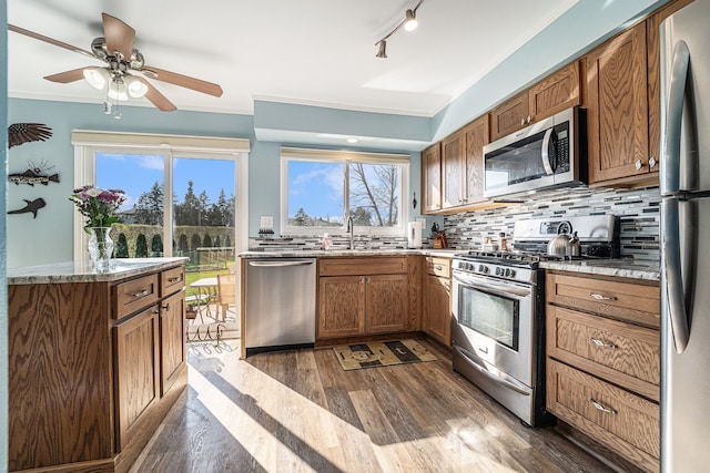 kitchen with dark wood-style floors, a sink, backsplash, and appliances with stainless steel finishes