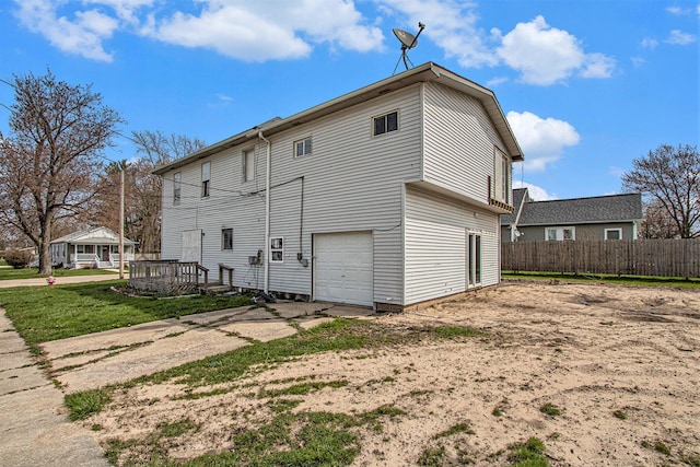 202 Poplar St, Three Oaks, MI 49128 - rear view of property featuring fence, driveway, and a garage