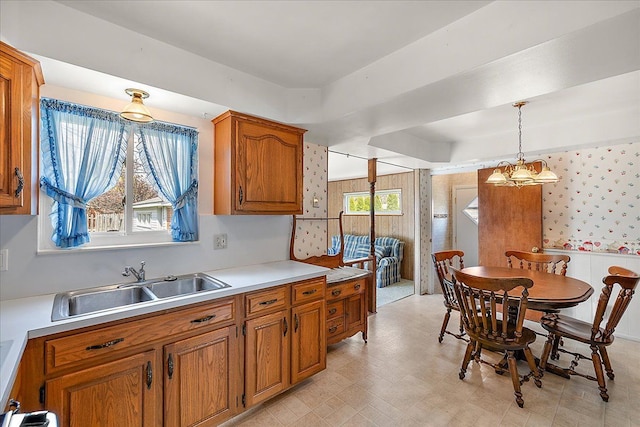 14953 Colpaert Dr, Warren, MI 48088 - kitchen with hanging light fixtures, brown cabinets, a sink, light countertops, and light floors