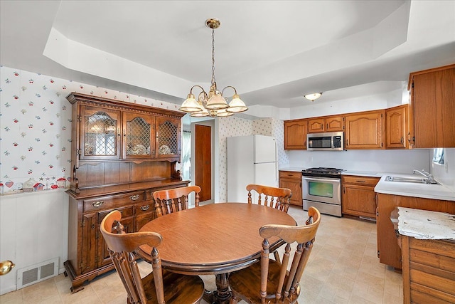 14953 Colpaert Dr, Warren, MI 48088 - dining space with wallpapered walls, an inviting chandelier, a tray ceiling, and visible vents