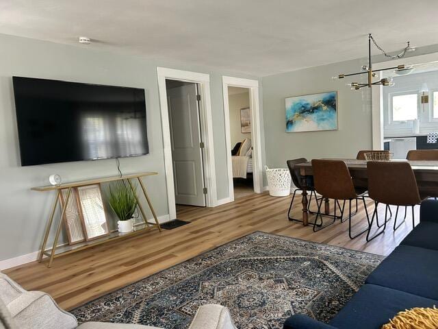 21 River St, Niles, MI 49120 - living room with wood finished floors, baseboards, and an inviting chandelier