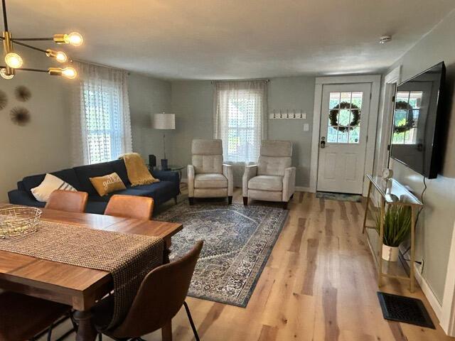 21 River St, Niles, MI 49120 - living room featuring a wealth of natural light, a chandelier, light wood-style floors, and visible vents