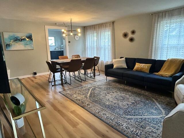 21 River St, Niles, MI 49120 - living room featuring an inviting chandelier, wood finished floors, and baseboards