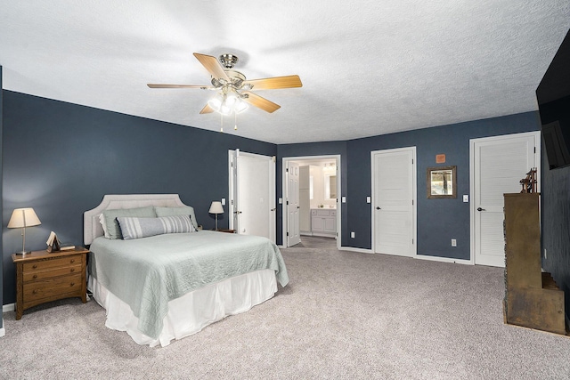 bedroom with baseboards, a textured ceiling, carpet flooring, ceiling fan, and ensuite bathroom