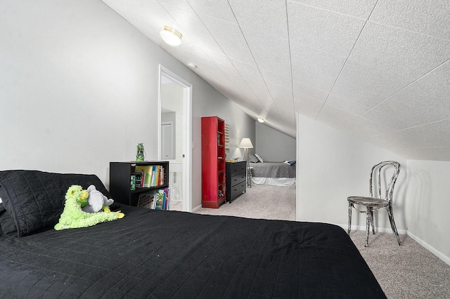 carpeted bedroom featuring vaulted ceiling and baseboards