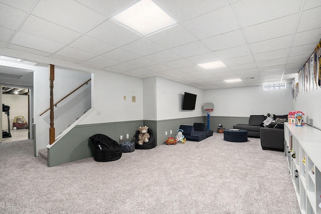 interior space with stairway, a drop ceiling, and wainscoting