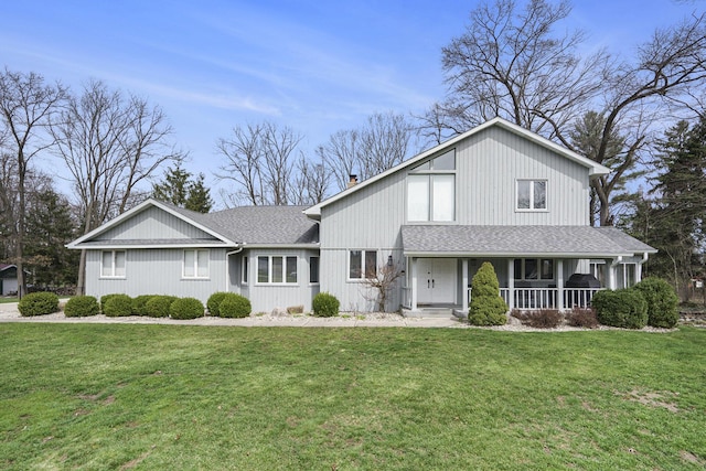 view of front of home with a porch, a front yard, and a shingled roof