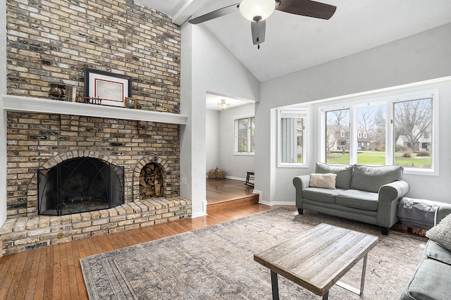 living room with beamed ceiling, a ceiling fan, high vaulted ceiling, and wood-type flooring