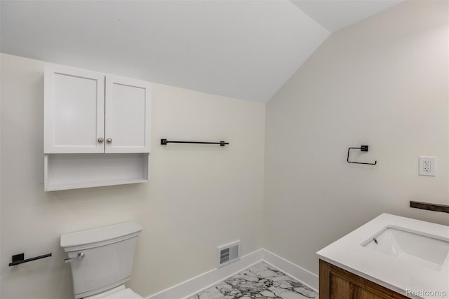 12061 Nashville St, Detroit, MI 48205 - bathroom with baseboards, marble look tile flooring, vanity, toilet, and vaulted ceiling