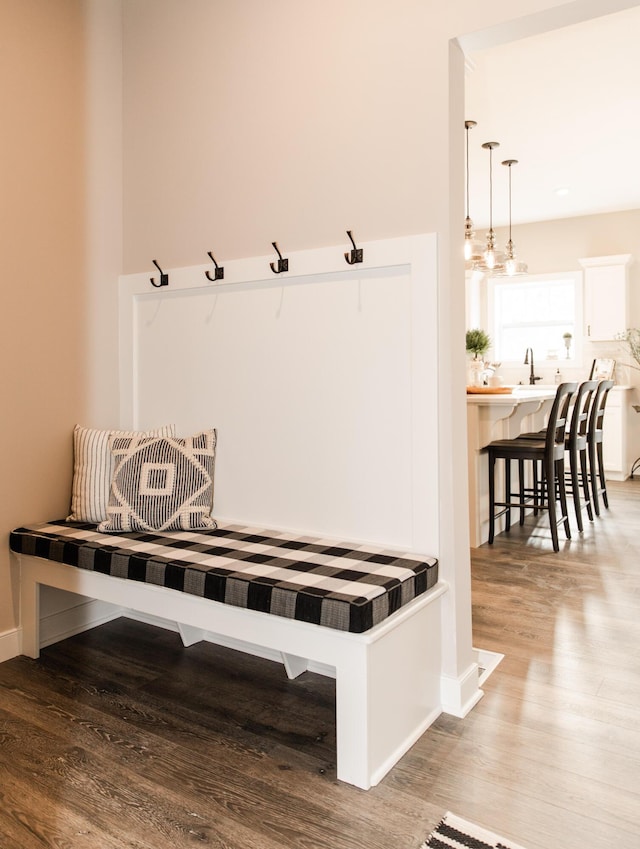 mudroom with baseboards, wood finished floors, and a sink