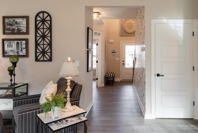foyer featuring visible vents, baseboards, and wood finished floors