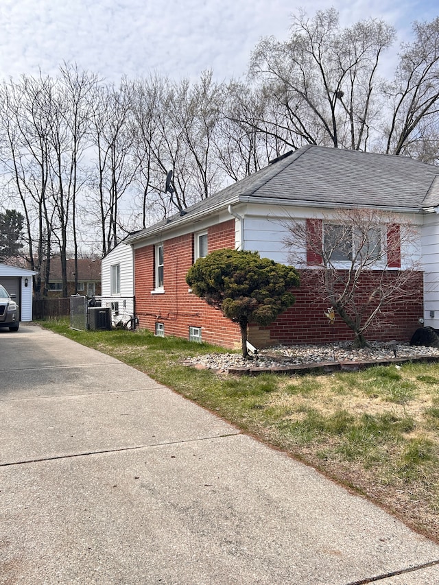 13973 Brady, Redford, MI 48239 - view of home's exterior featuring cooling unit, driveway, brick siding, and a shingled roof