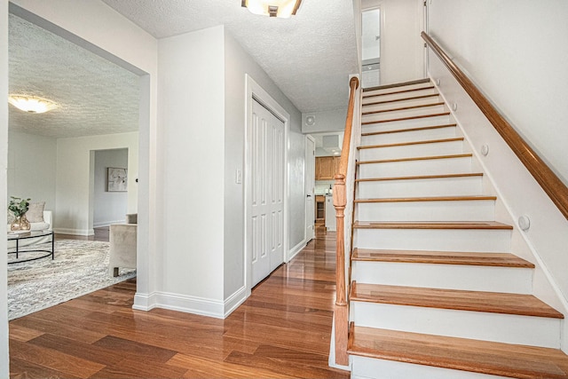 2569 Ridgewood Trl, Berrien Springs, MI 49103 - staircase with baseboards, wood finished floors, and a textured ceiling