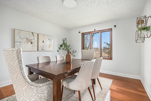 2569 Ridgewood Trl, Berrien Springs, MI 49103 - dining area featuring light wood-style flooring, a textured ceiling, and baseboards