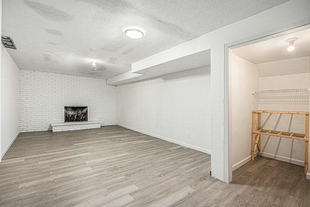 2569 Ridgewood Trl, Berrien Springs, MI 49103 - finished basement featuring baseboards, visible vents, wood finished floors, and a textured ceiling
