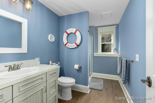 6501 Andres Xing Unit 14, Grandville, MI 49418 - full bathroom featuring toilet, a stall shower, baseboards, wood finished floors, and vanity