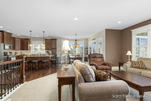 6501 Andres Xing Unit 14, Grandville, MI 49418 - living area featuring baseboards, an inviting chandelier, dark wood-type flooring, and recessed lighting