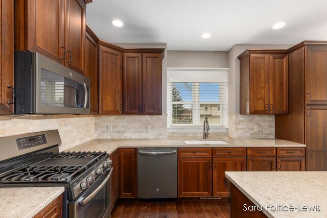 6501 Andres Xing Unit 14, Grandville, MI 49418 - kitchen with a sink, decorative backsplash, stainless steel appliances, light stone countertops, and dark wood-style floors