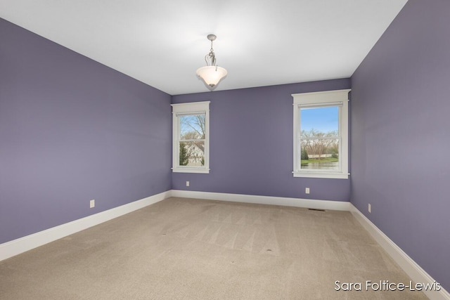 6501 Andres Xing Unit 14, Grandville, MI 49418 - empty room with visible vents, light carpet, baseboards, and a wealth of natural light