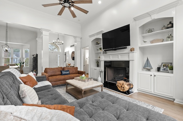 2693 Sanctuary Dr, Stevensville, MI 49127 - living area with light wood-style flooring, built in features, ornate columns, and ceiling fan with notable chandelier