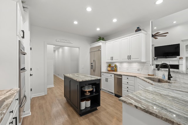 2693 Sanctuary Dr, Stevensville, MI 49127 - kitchen with ceiling fan, light wood finished floors, a sink, built in refrigerator, and white cabinetry
