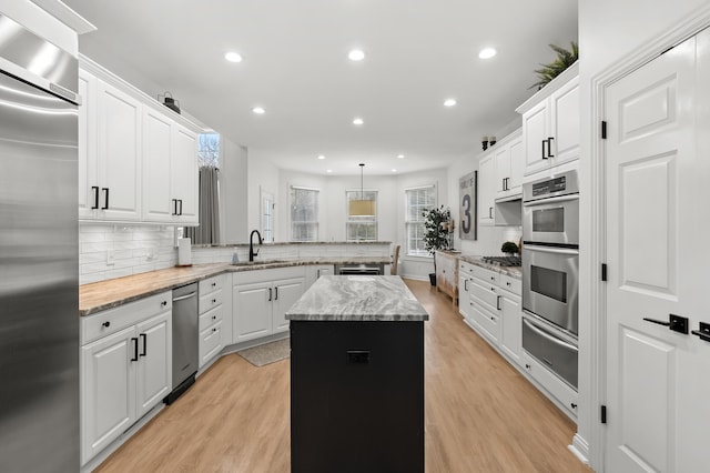 2693 Sanctuary Dr, Stevensville, MI 49127 - kitchen featuring a warming drawer, a kitchen island, a peninsula, tasteful backsplash, and appliances with stainless steel finishes