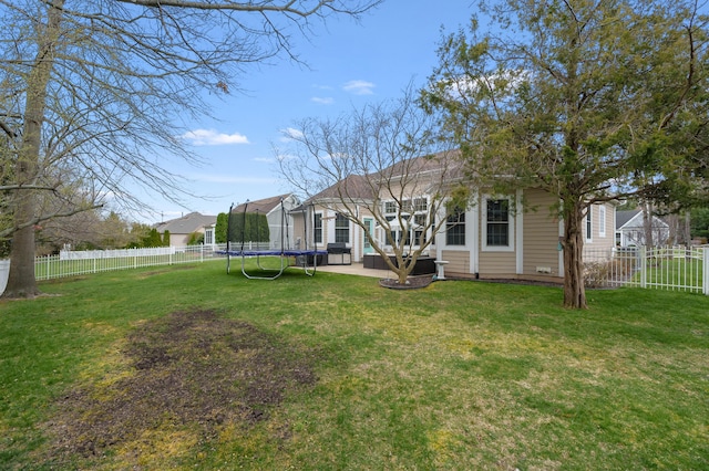 2693 Sanctuary Dr, Stevensville, MI 49127 - back of house featuring a lawn, a fenced backyard, a patio, and a trampoline