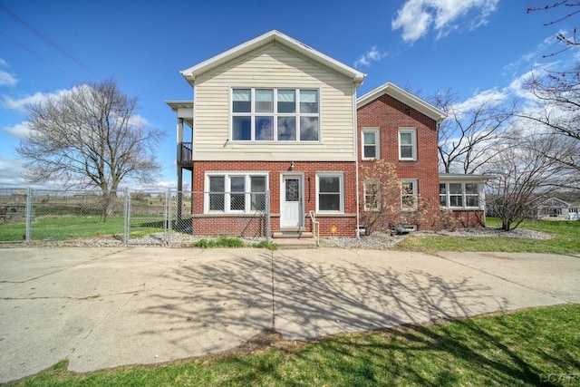 back of property featuring brick siding, fence, and a balcony
