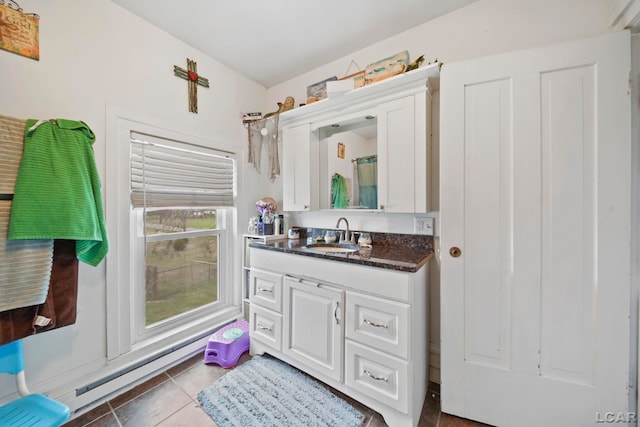 full bathroom with a baseboard heating unit, vanity, and tile patterned flooring