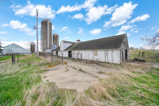 rear view of property featuring fence, an outbuilding, and a barn