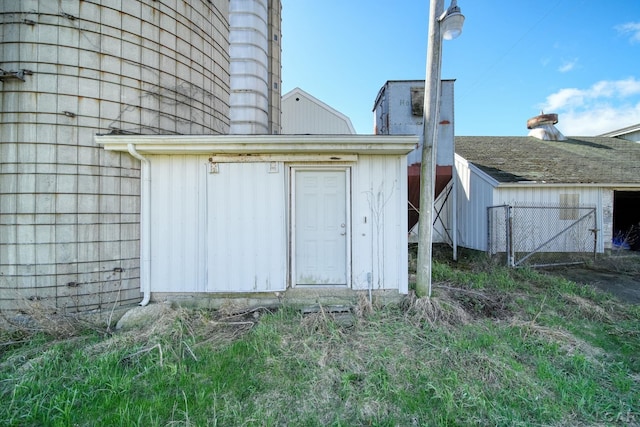 view of outbuilding featuring fence and an outbuilding