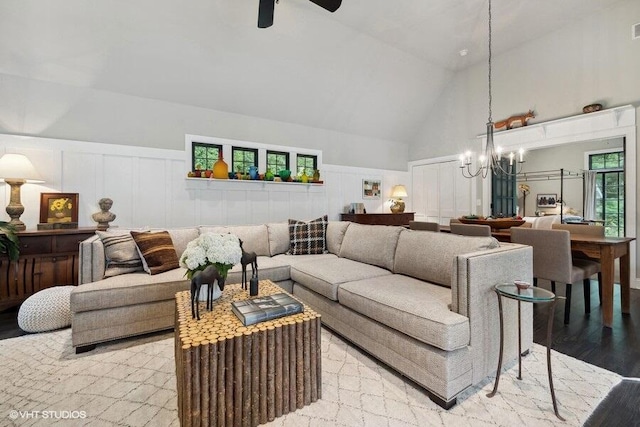 16191 4th Ln, Union Pier, MI 49129 - living room with a wainscoted wall, a decorative wall, light wood-style flooring, high vaulted ceiling, and ceiling fan with notable chandelier