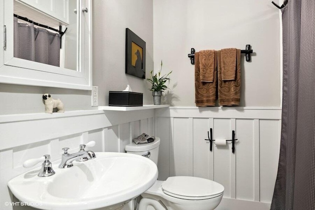 16191 4th Ln, Union Pier, MI 49129 - full bathroom with a wainscoted wall, toilet, a shower with curtain, a sink, and a decorative wall